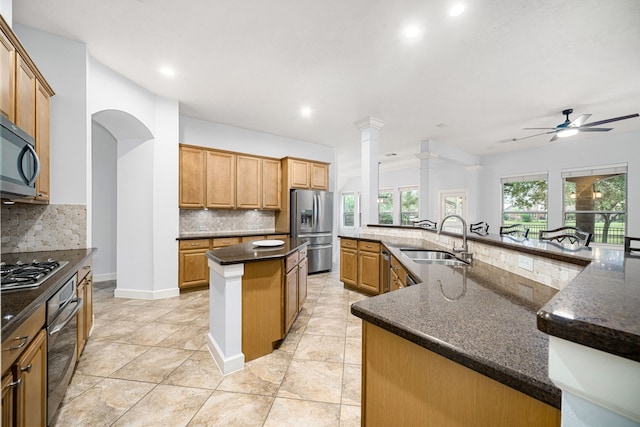 kitchen featuring tasteful backsplash, stainless steel appliances, a kitchen island with sink, and sink