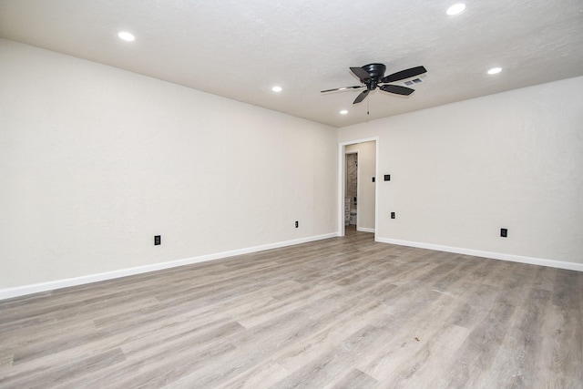 spare room featuring ceiling fan, light hardwood / wood-style floors, and a textured ceiling