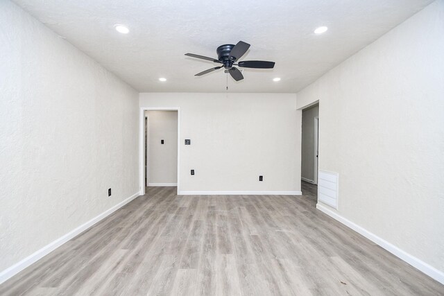 spare room with ceiling fan, a textured ceiling, and light hardwood / wood-style flooring