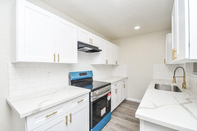 kitchen with sink, light stone counters, stainless steel range with electric stovetop, white cabinets, and light wood-type flooring