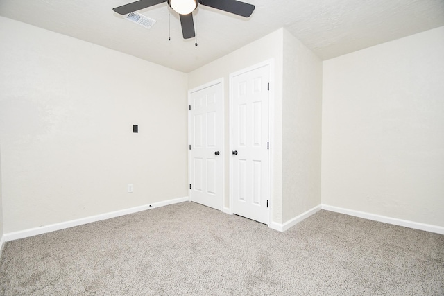 unfurnished bedroom featuring carpet flooring, a textured ceiling, and ceiling fan