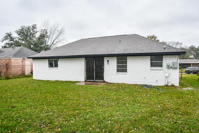 rear view of property featuring a yard