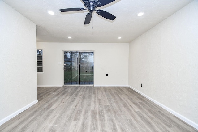 empty room featuring ceiling fan, light hardwood / wood-style floors, and a textured ceiling