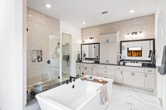 bathroom featuring plus walk in shower, vanity, and tile walls