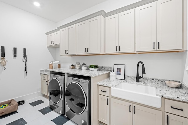 washroom with washer and dryer, sink, and cabinets