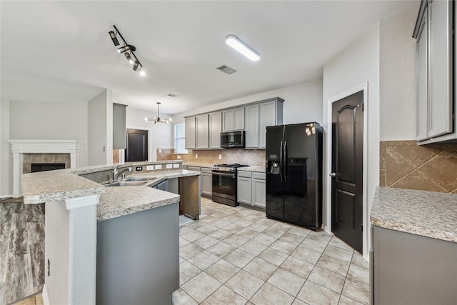 kitchen with sink, tasteful backsplash, pendant lighting, gray cabinets, and black appliances