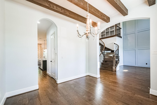 unfurnished dining area featuring dark hardwood / wood-style flooring, beamed ceiling, a chandelier, and sink