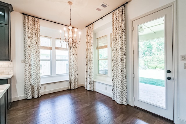 unfurnished dining area with a chandelier and dark wood-type flooring