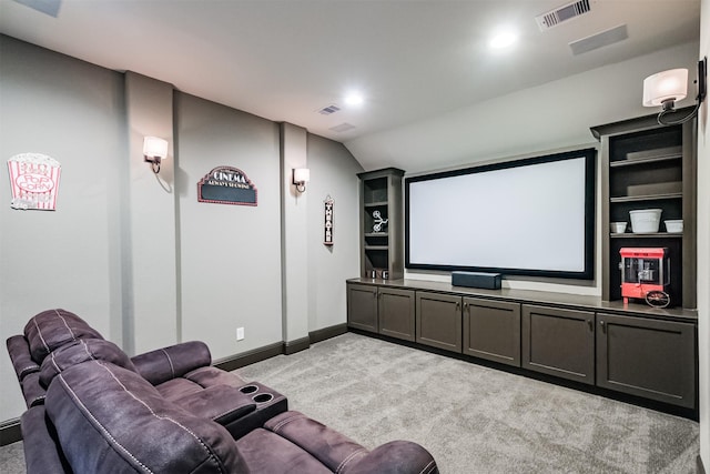 cinema with light colored carpet and vaulted ceiling