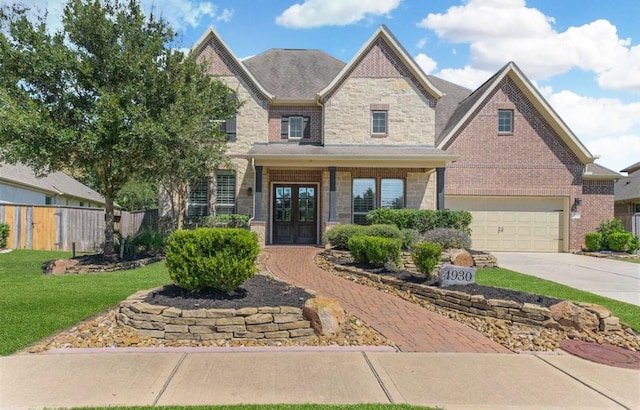 view of front of home featuring french doors, a garage, and a front lawn