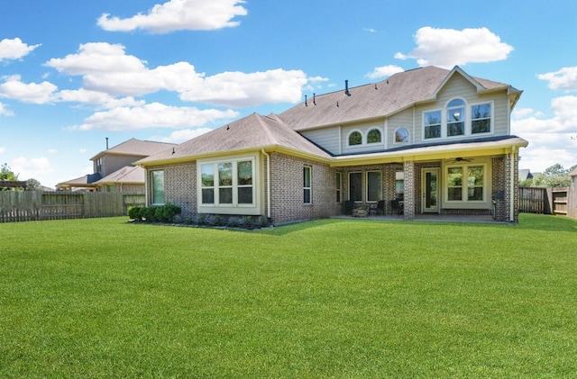 back of house with ceiling fan, a patio area, and a yard