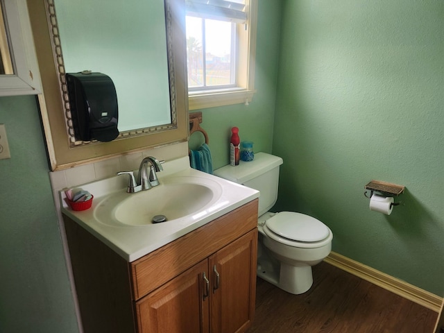 bathroom with vanity, toilet, and hardwood / wood-style floors