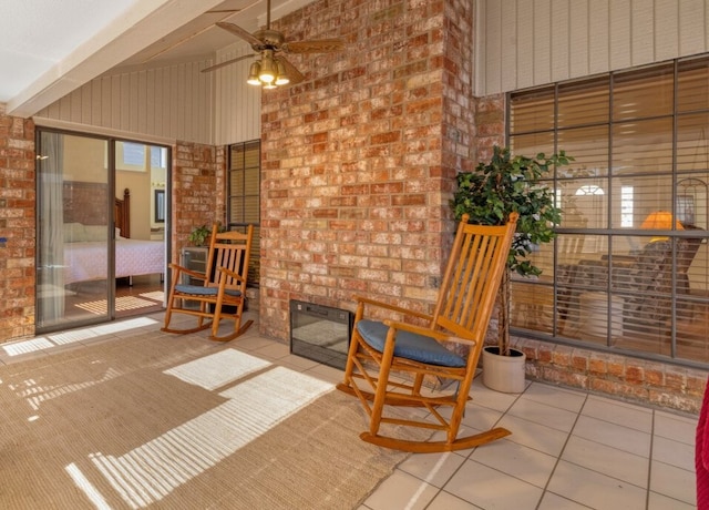 living room featuring beam ceiling, a fireplace, ceiling fan, and tile patterned flooring