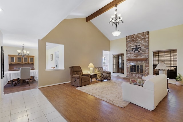 living room with beam ceiling, high vaulted ceiling, an inviting chandelier, a fireplace, and light tile patterned flooring