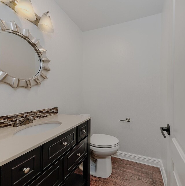 bathroom featuring hardwood / wood-style floors, vanity, and toilet