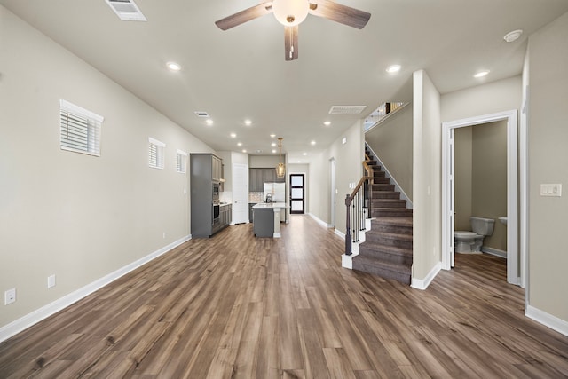 unfurnished living room featuring dark hardwood / wood-style floors and ceiling fan