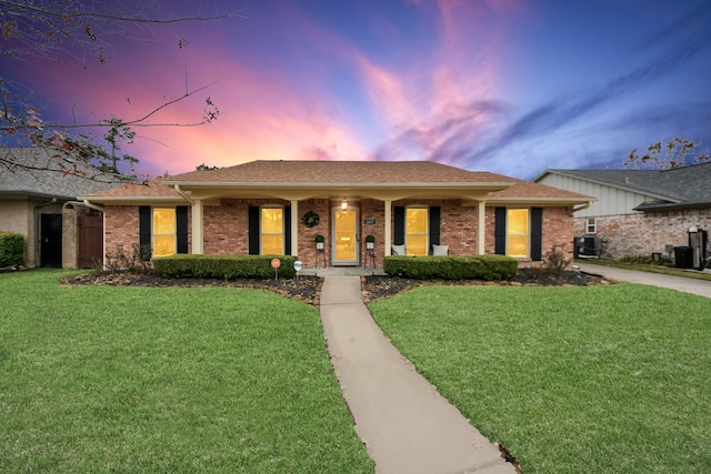 ranch-style home with a yard, cooling unit, and covered porch