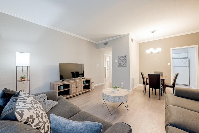 living room featuring a chandelier, light hardwood / wood-style floors, and ornamental molding