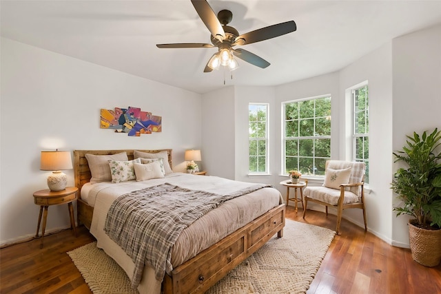 bedroom with dark hardwood / wood-style flooring and ceiling fan