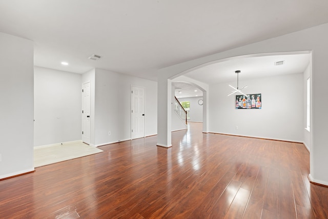 spare room featuring a chandelier and hardwood / wood-style flooring