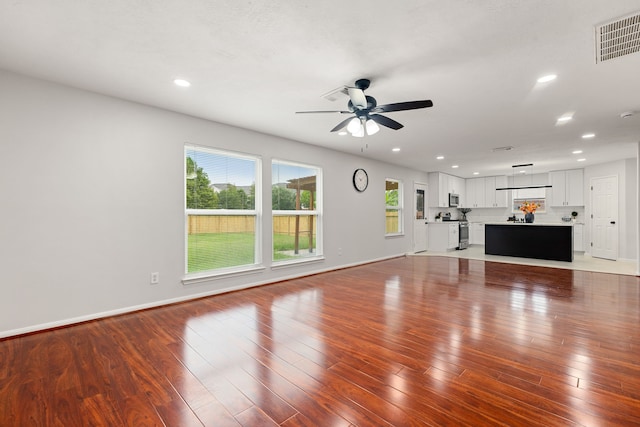 unfurnished living room featuring wood-type flooring and ceiling fan