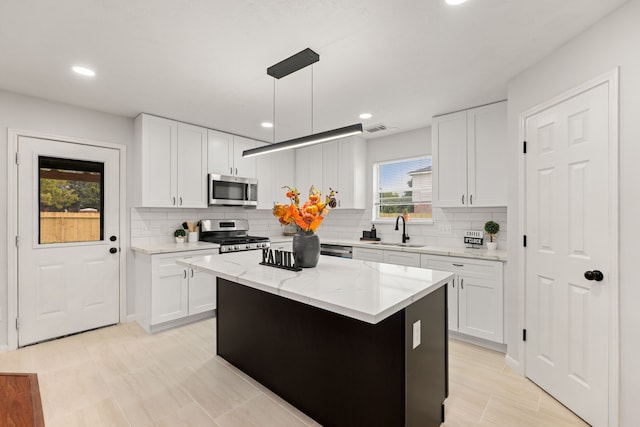 kitchen featuring white cabinets, a kitchen island, and appliances with stainless steel finishes