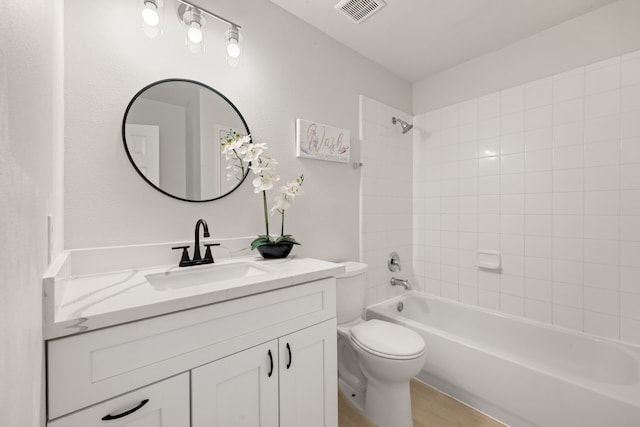 full bathroom featuring toilet, vanity, and tiled shower / bath