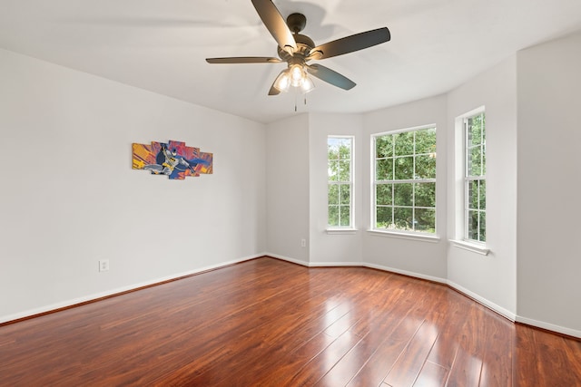 empty room with ceiling fan, hardwood / wood-style floors, and a healthy amount of sunlight