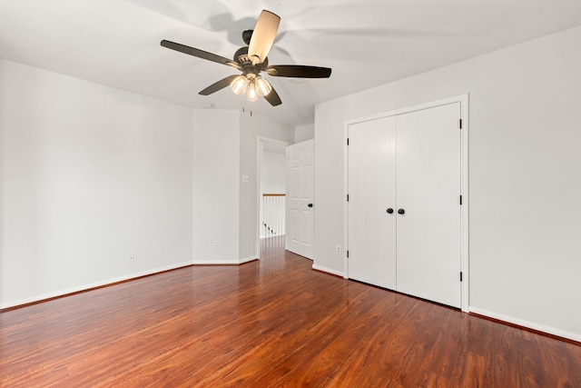 unfurnished bedroom with a closet, ceiling fan, and dark wood-type flooring