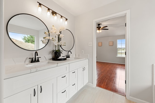 bathroom featuring wood-type flooring, vanity, ceiling fan, and a healthy amount of sunlight