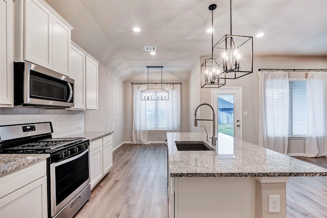 kitchen featuring a center island with sink, pendant lighting, sink, and appliances with stainless steel finishes