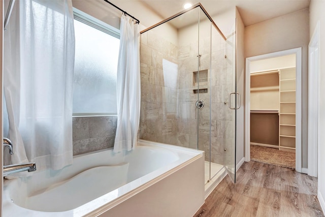 bathroom featuring separate shower and tub and wood-type flooring