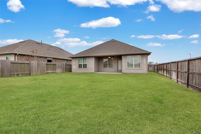 rear view of property featuring a yard and a patio area