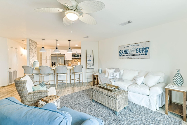 living room featuring hardwood / wood-style flooring and ceiling fan