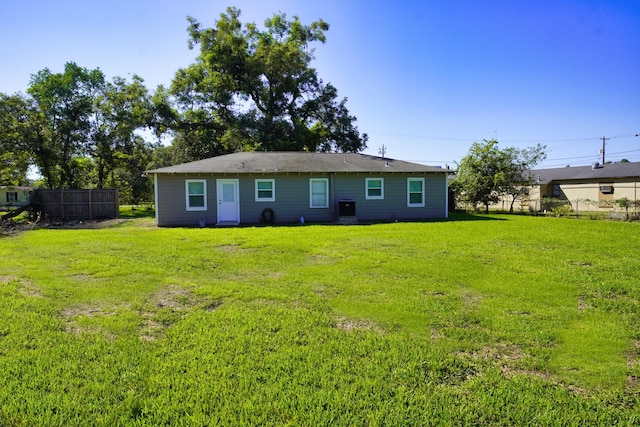 rear view of property featuring a lawn