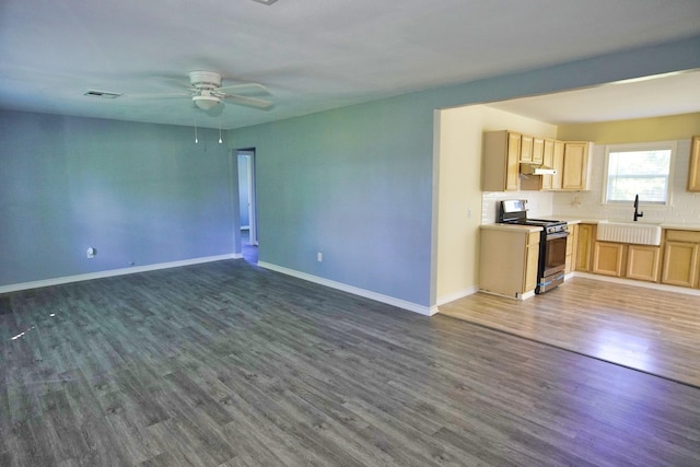 unfurnished living room with dark hardwood / wood-style floors, ceiling fan, and sink