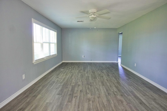 empty room with ceiling fan and dark hardwood / wood-style flooring