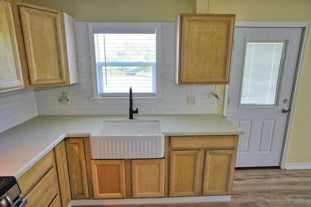 kitchen featuring electric stove, decorative backsplash, sink, and light hardwood / wood-style floors