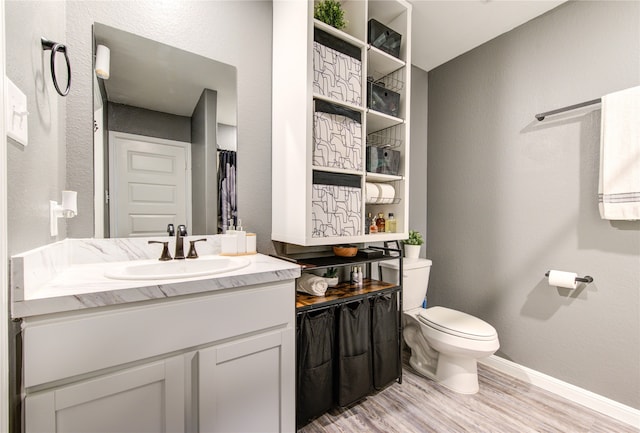 bathroom with hardwood / wood-style floors, vanity, and toilet