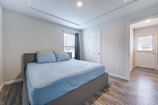 bedroom with dark hardwood / wood-style flooring and multiple windows