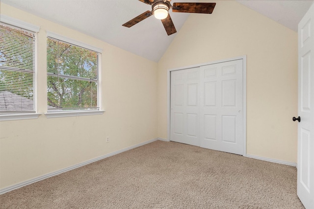 unfurnished bedroom featuring ceiling fan, lofted ceiling, light carpet, and a closet