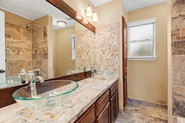 bathroom featuring a textured ceiling and vanity