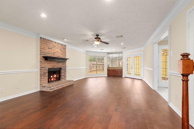 unfurnished living room featuring ceiling fan, a fireplace, dark hardwood / wood-style floors, and ornamental molding