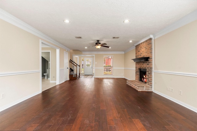 unfurnished living room with a textured ceiling, ceiling fan, crown molding, and a fireplace