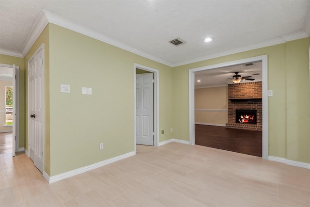 interior space featuring crown molding, a fireplace, ceiling fan, and a textured ceiling