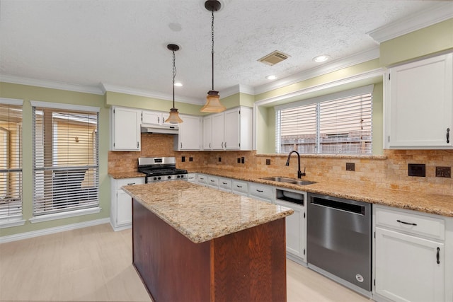 kitchen with pendant lighting, white cabinetry, sink, and stainless steel appliances