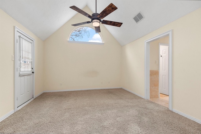 carpeted spare room featuring ceiling fan and lofted ceiling