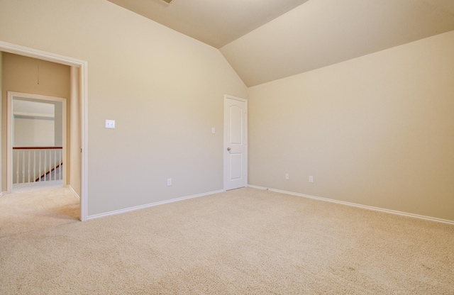 carpeted spare room featuring lofted ceiling