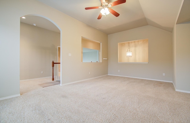 spare room with carpet flooring, vaulted ceiling, and ceiling fan