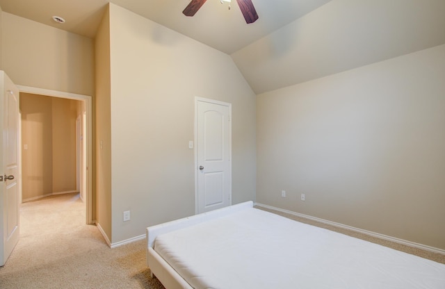 bedroom with ceiling fan, light colored carpet, and vaulted ceiling